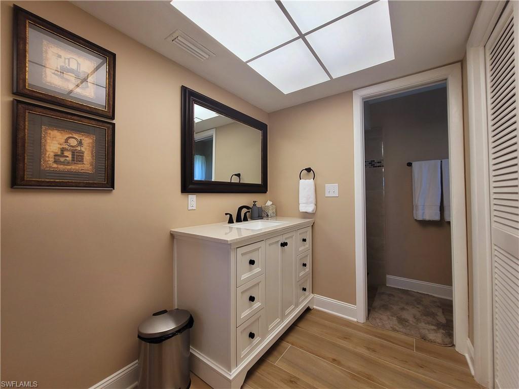 Bathroom featuring a white vanity with black hardware, a rectangular white sink, and a black framed mirror