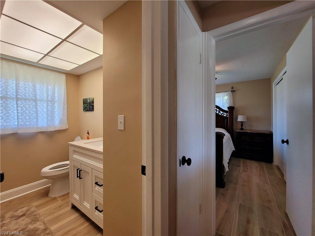 Bathroom featuring a white vanity with black hardware, an integrated sink, and a toilet
