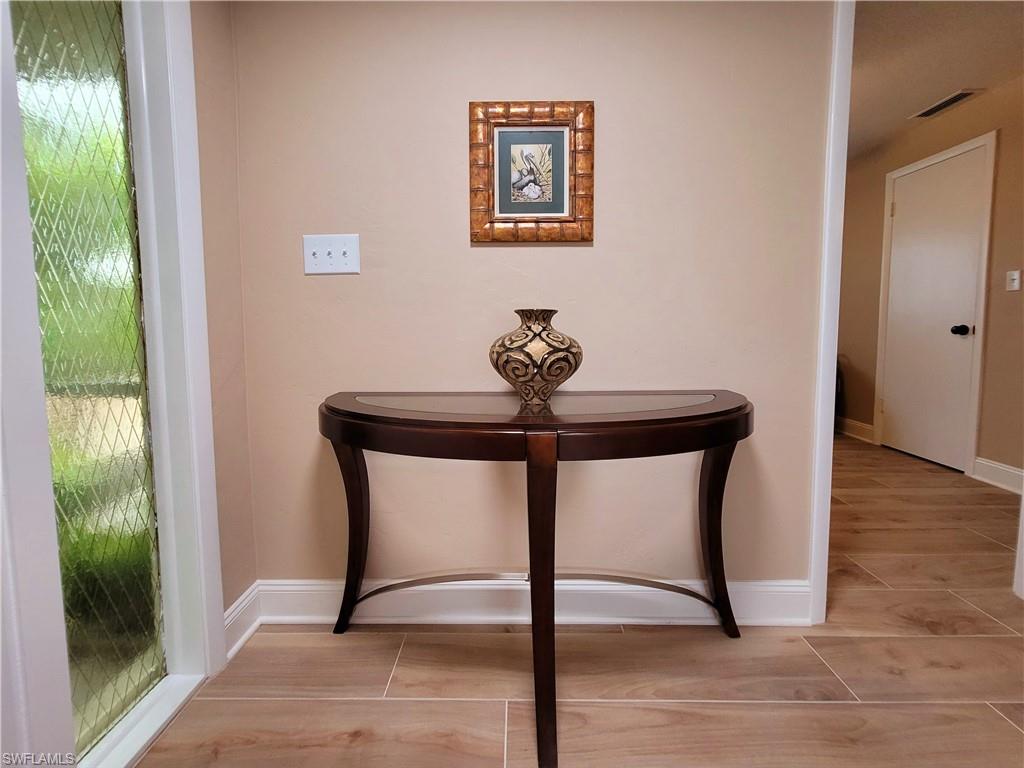Entryway featuring wood-finish tile flooring and a decorative sidelight with patterned glass