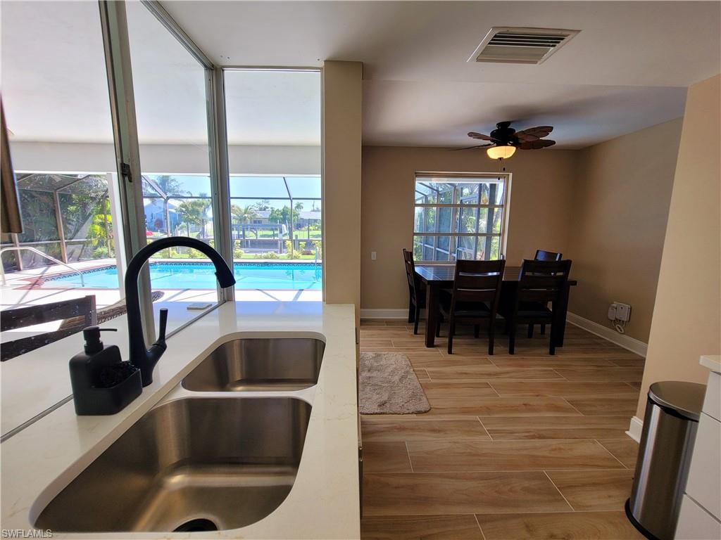 Kitchen sink with stainless steel double basin, matte black faucet, and white countertop