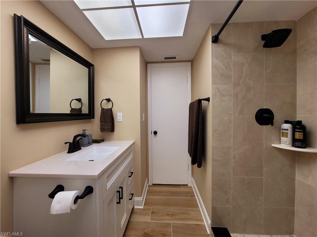 Contemporary bathroom featuring a white single-sink vanity with quartz countertop and matte black fixtures