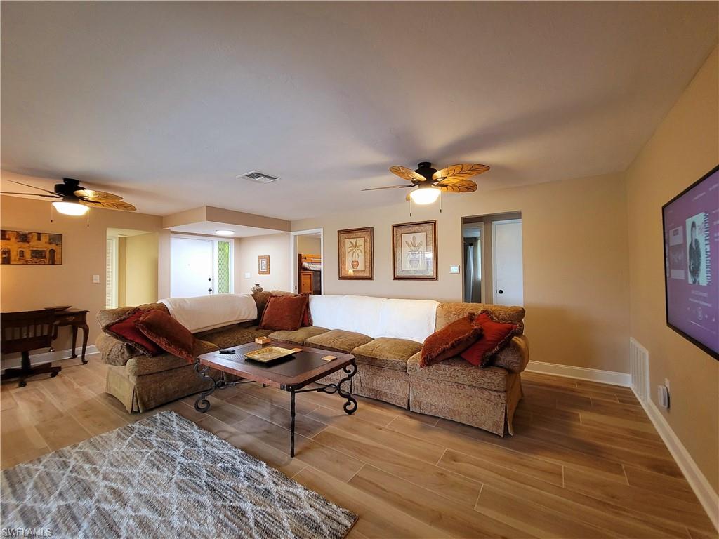 Open-concept living space featuring wood-finish flooring, recessed lighting, and ceiling fans