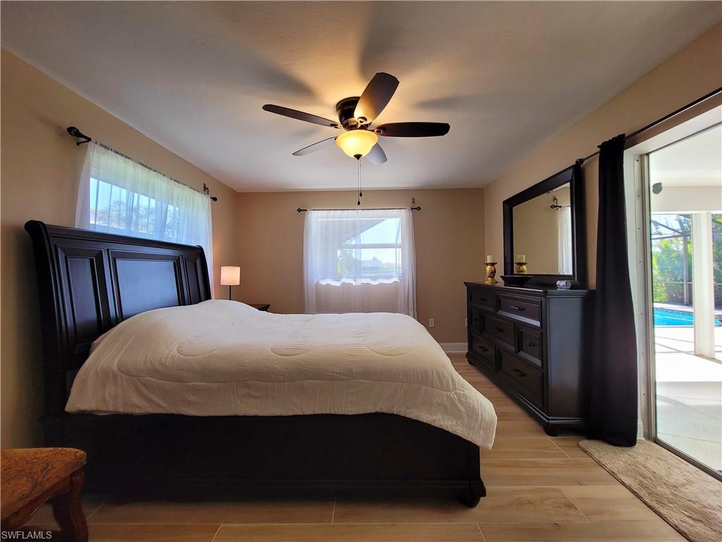 Spacious interior featuring wood-finish flooring, a ceiling fan with integrated lighting, and multiple windows