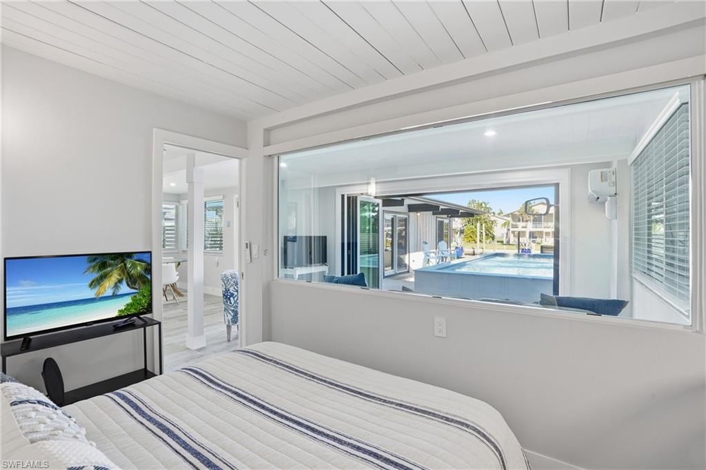 Bedroom featuring pool views - Virtually Edited Image