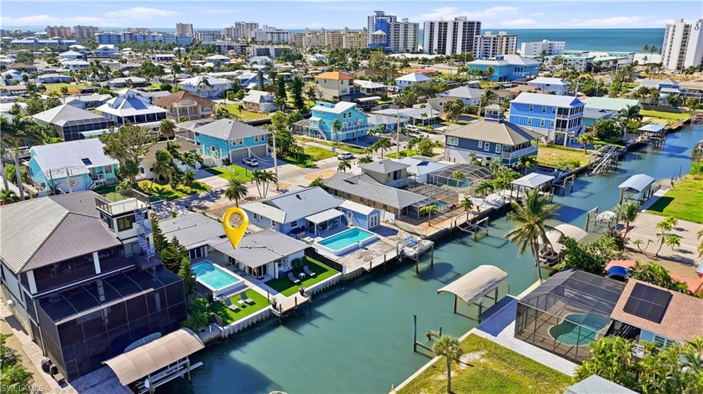 Rear view of property with pool, yard, and water views - Virtually Edited Image