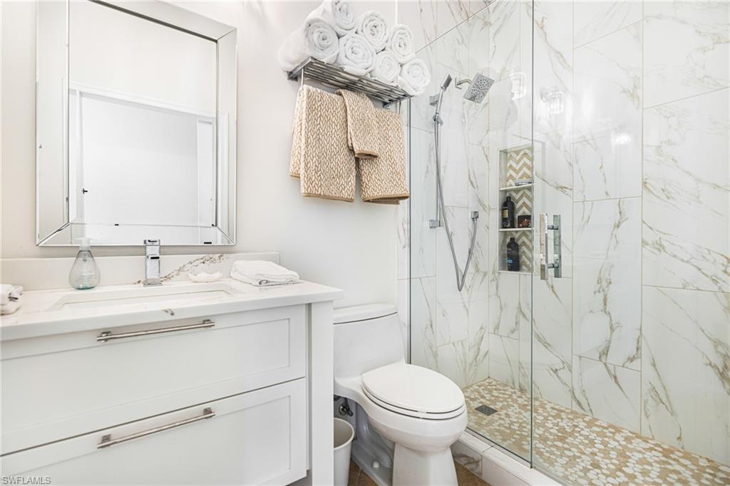 Bathroom featuring vanity, toilet, and a shower with shower door