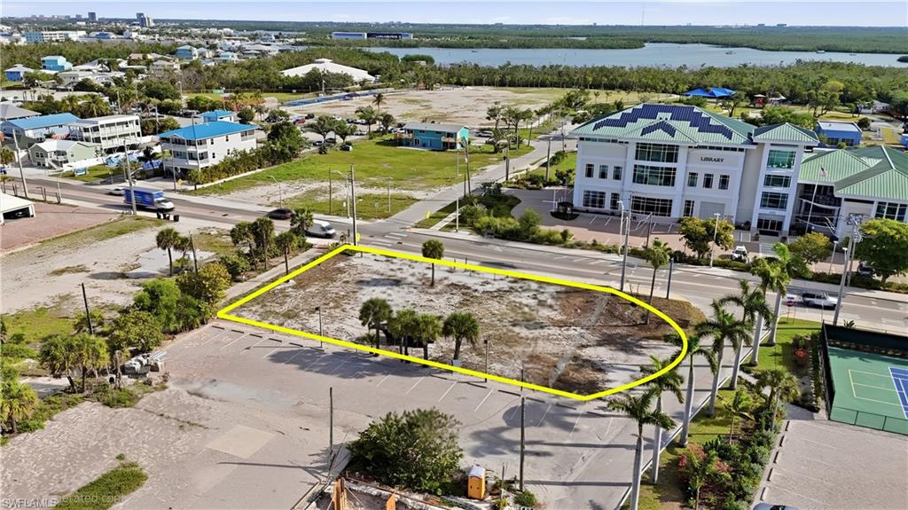 Cleared land parcel featuring mature palm trees and direct road frontage - Virtually Edited Image