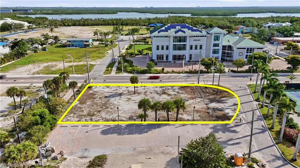 Expansive corner lot featuring mature palm trees and direct road frontage - Virtually Edited Image