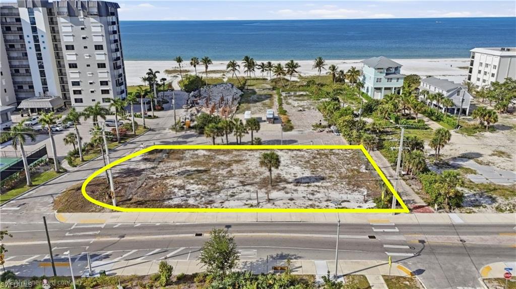 Expansive level lot featuring partial perimeter paving, surrounding palm trees, and ocean proximity - Virtually Edited Image