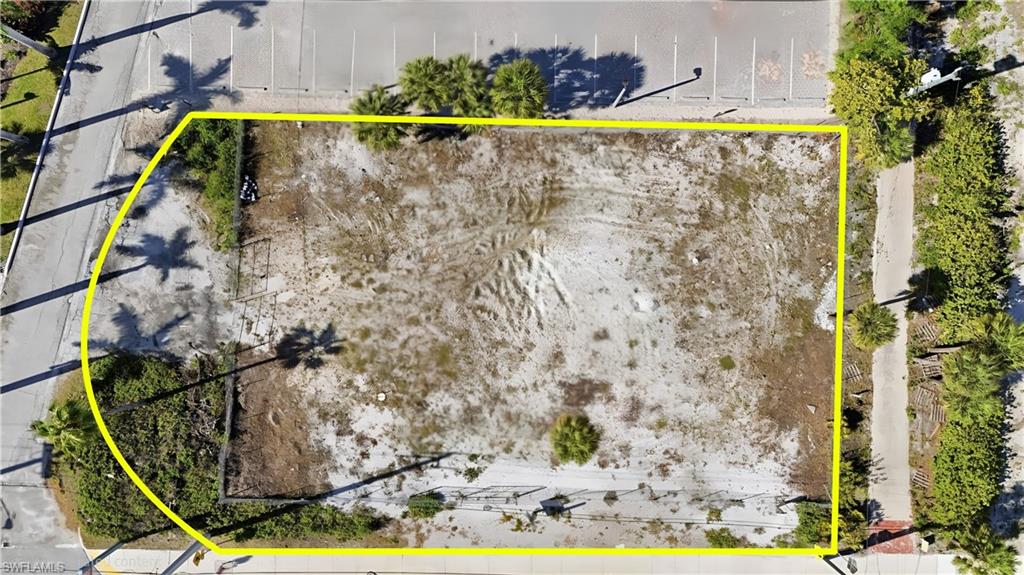Cleared lot featuring a defined perimeter, partial fencing, and proximity to paved roadways - Virtually Edited Image