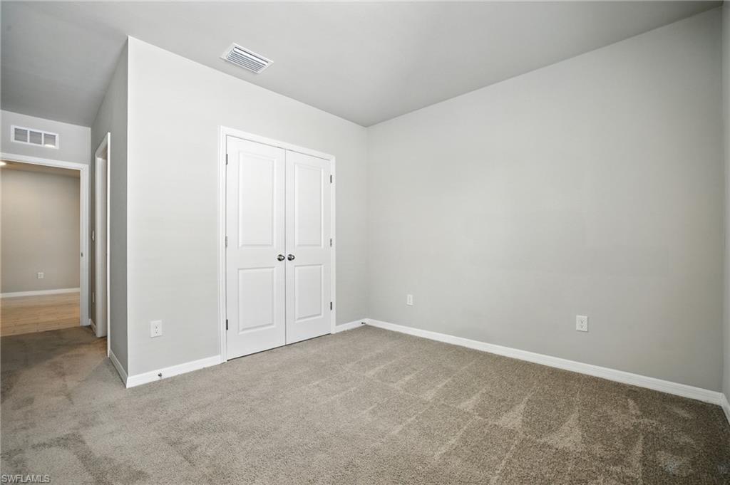 Room featuring light gray wall paint, white trim, and neutral-toned carpet flooring