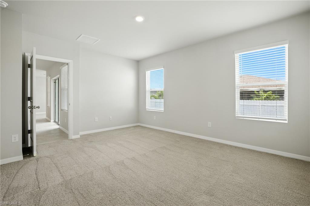 Spacious room featuring neutral carpeting and light-toned walls