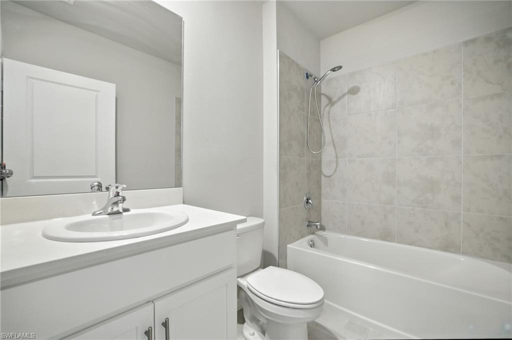 Bathroom featuring a white vanity with an undermount sink, chrome faucet, and a large wall-mounted mirror