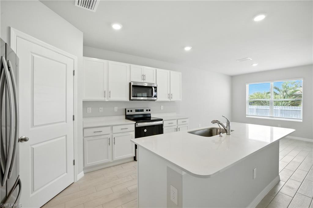Contemporary kitchen featuring a large central island with an undermount sink and gooseneck faucet