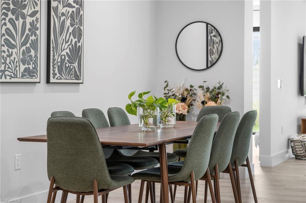 Dining area featuring a rectangular wood-finish table, upholstered chairs, and wood-finish flooring