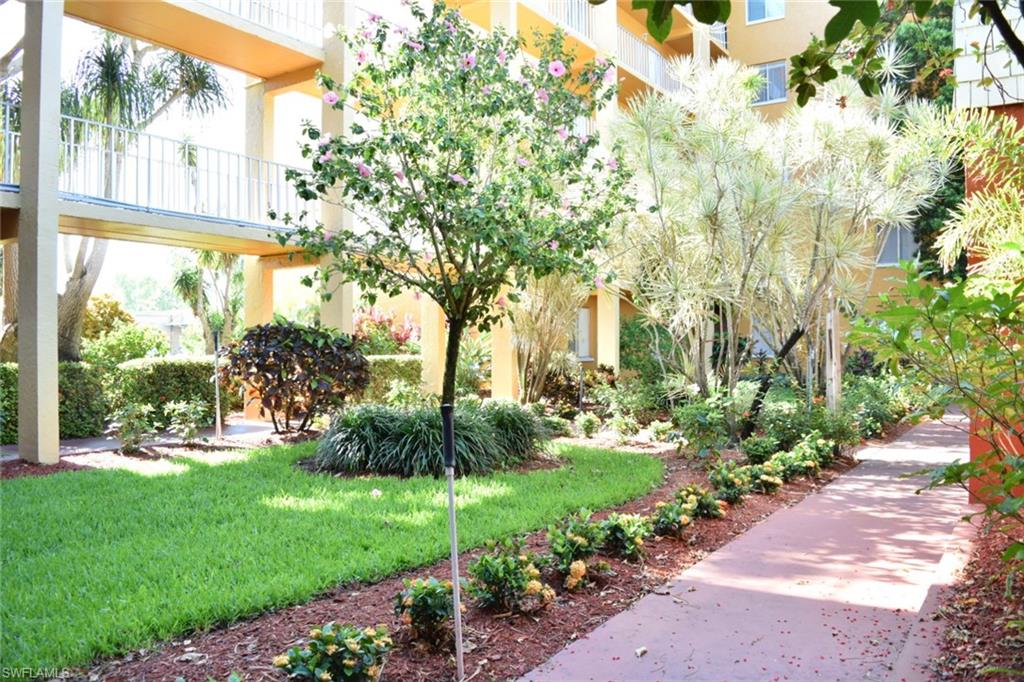 Lush, manicured landscaping with diverse plantings, mature trees, and a well-maintained lawn