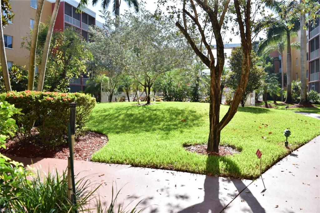 Lush green lawn with mature trees and manicured shrubbery