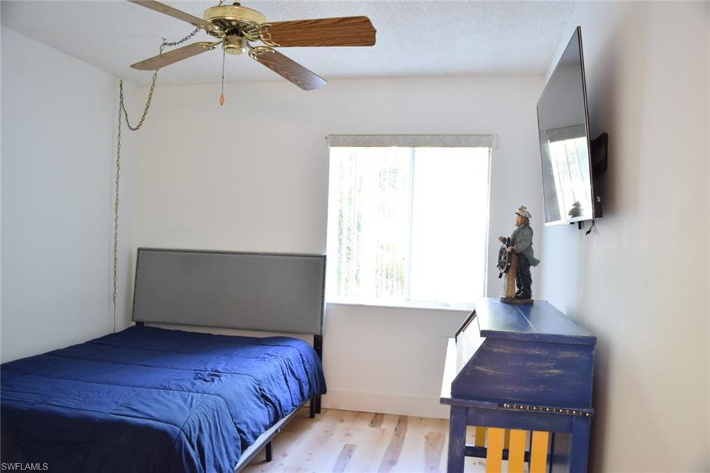 Bright room featuring wood-finish flooring and a ceiling fan