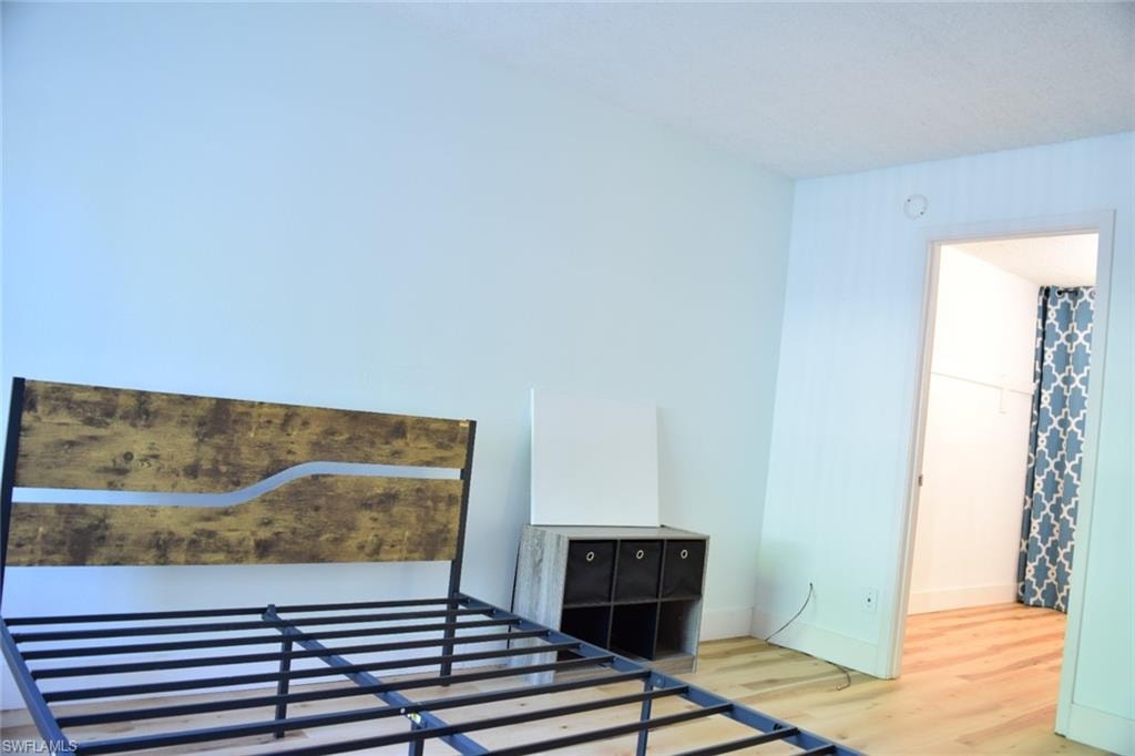Light-toned wood-finish flooring complements the neutral wall color