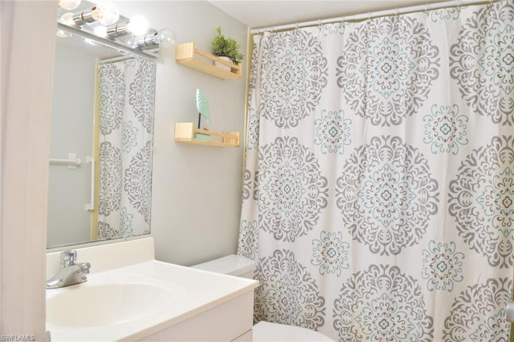 Bathroom featuring a single vanity with an integrated sink, polished chrome faucet, and a large wall-mounted mirror