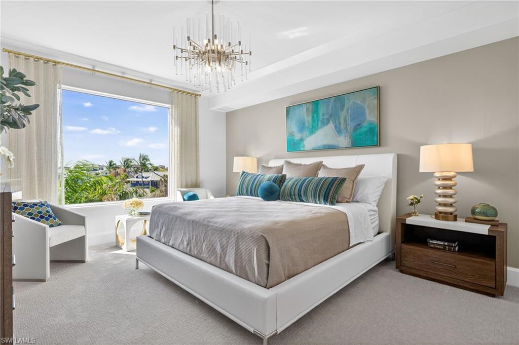 Coastal contemporary decor in this large master suite with an expansive window overlooking tropical landscaping