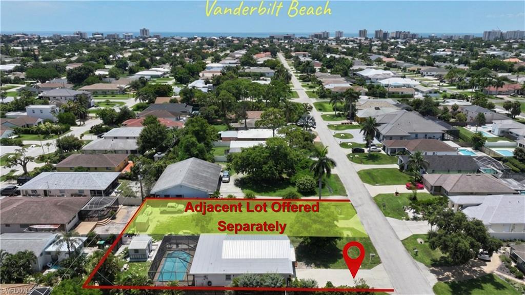 Aerial perspective of a residential neighborhood with a distant coastal skyline