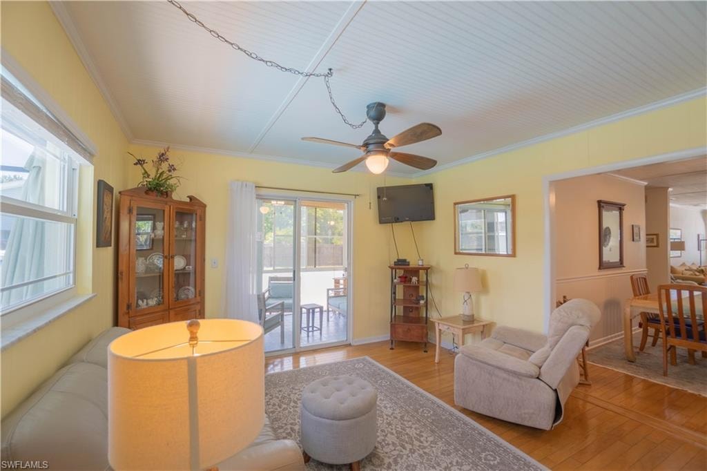 Living room featuring crown molding, hardwood / wood-style flooring, and ceiling fan
