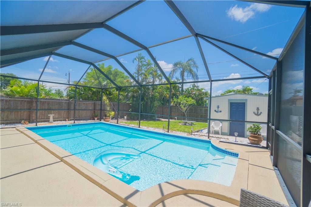View of pool with a lanai, a fenced backyard, a sunroom, and a patio area