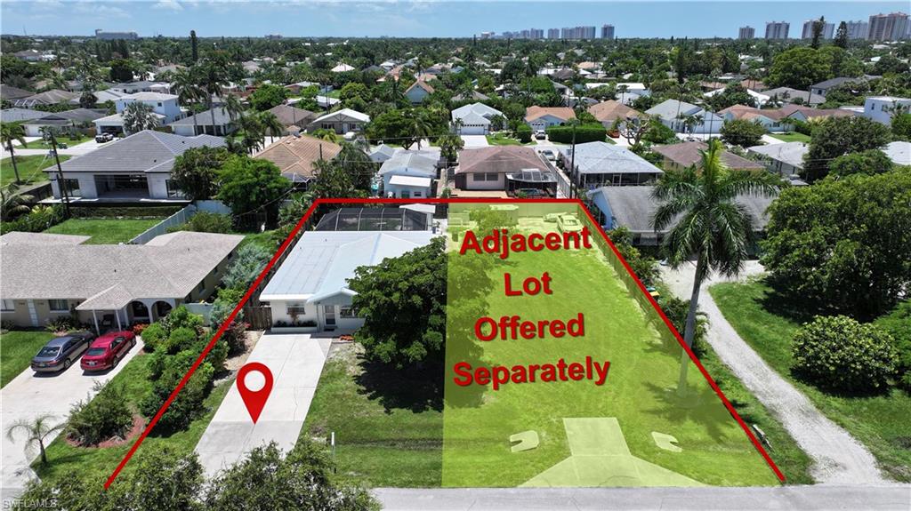 Single-story residence featuring a paved driveway, mature landscaping, and a screened rear patio