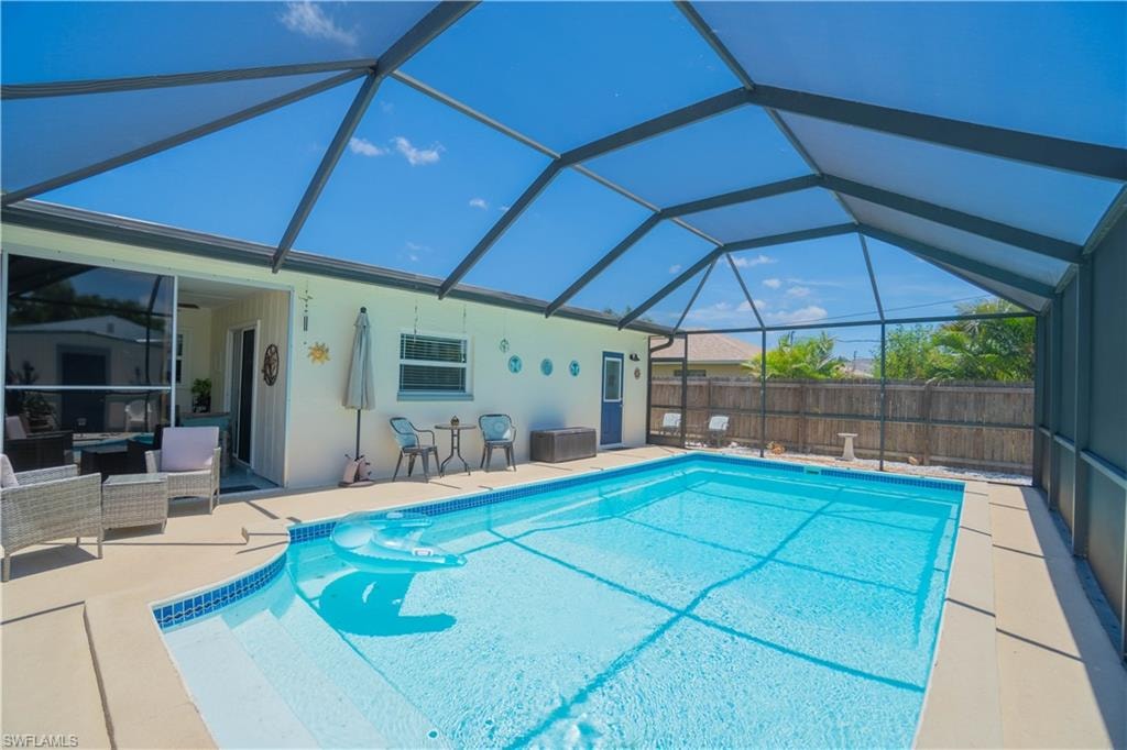 View of swimming pool with a patio, glass enclosure, a sunroom, and an outdoor hangout area