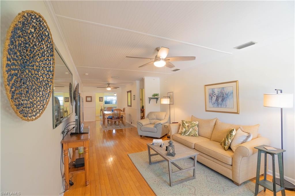 Living area featuring light wood-style flooring and ceiling fan