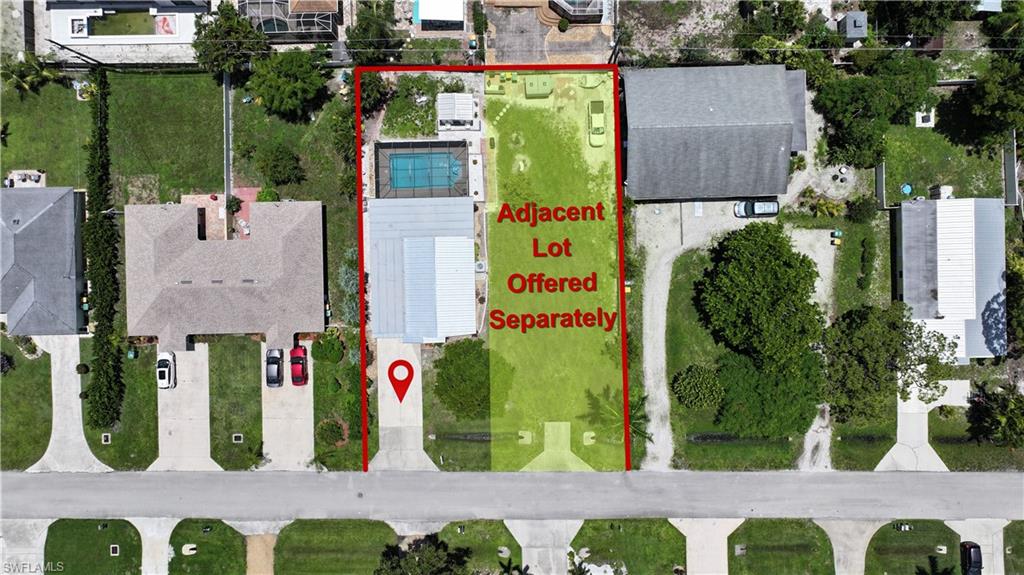 Property parcel featuring a paved driveway, a rectangular swimming pool, and a well-maintained lawn