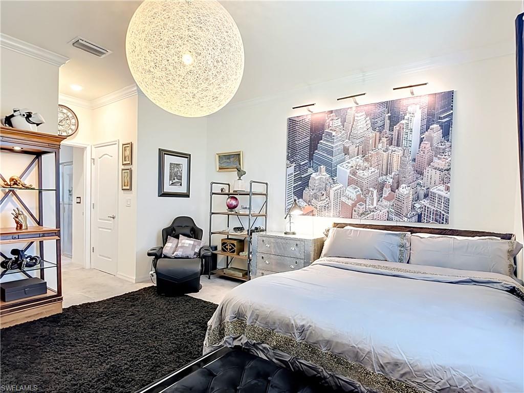 Spacious Primary Bedroom featuring light-colored walls and crown molding