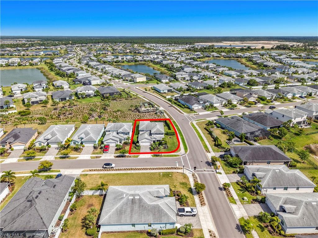 Aerial perspective showcasing a residential community with numerous single-story homes, many featuring private water access