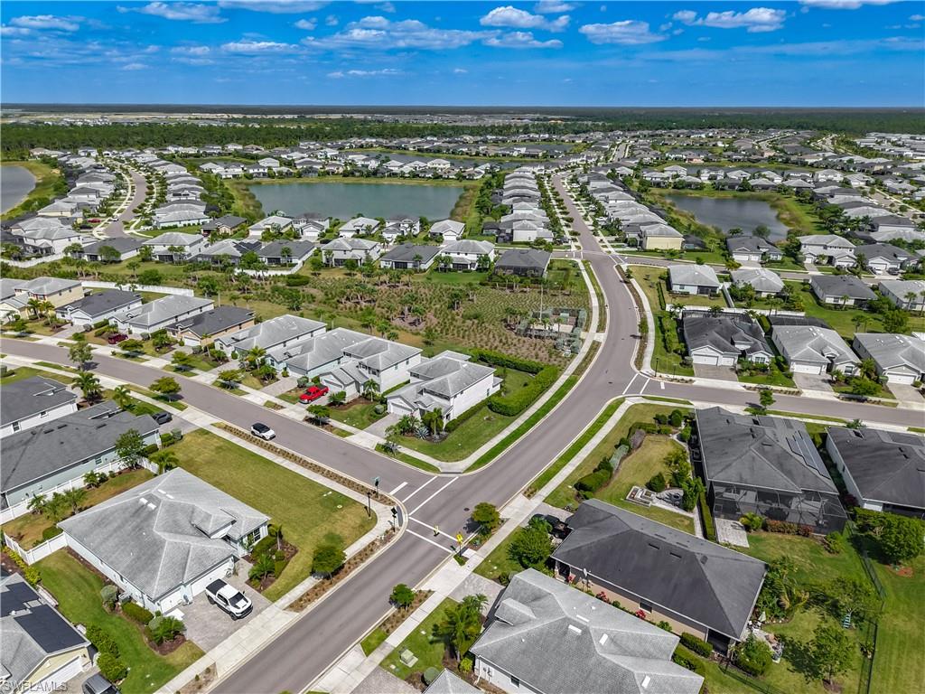 Expansive residential community featuring a network of paved streets, numerous single-story homes with shingle roofs, and multiple retention ponds