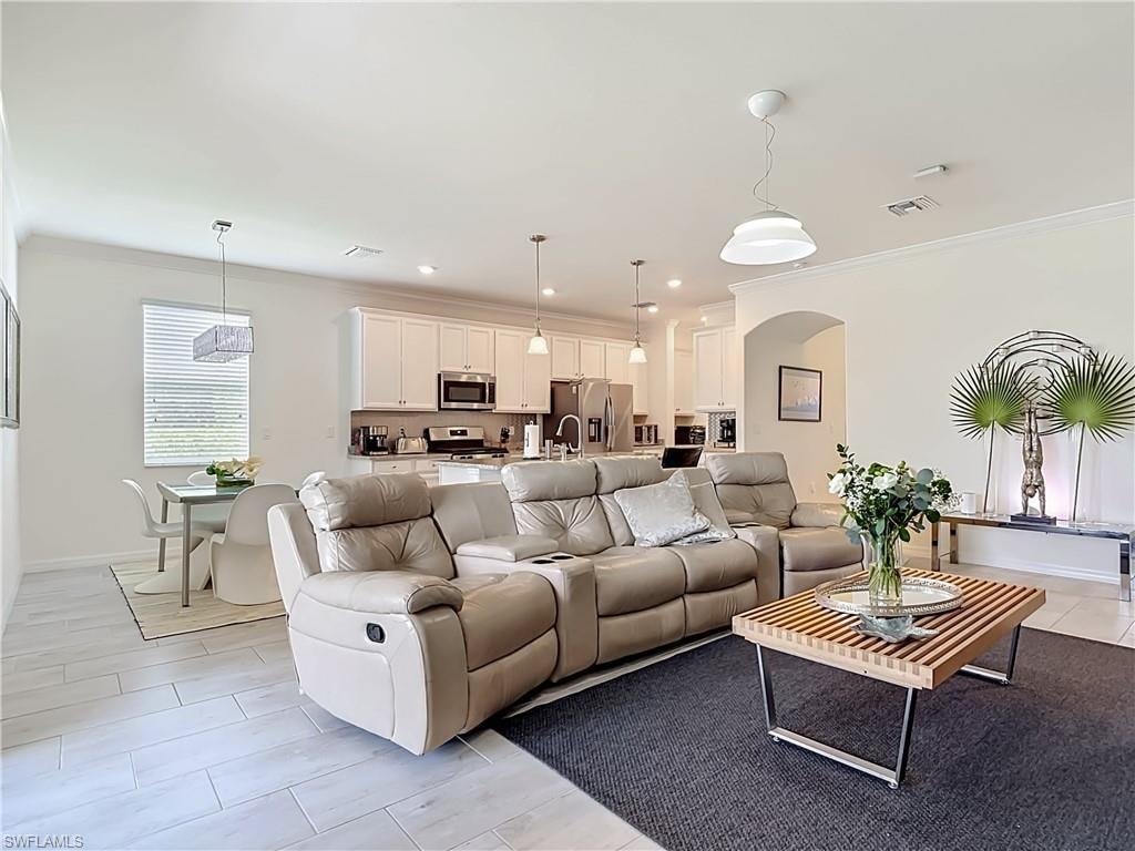 Open-concept living area featuring light wood-look tile flooring and white wall paint