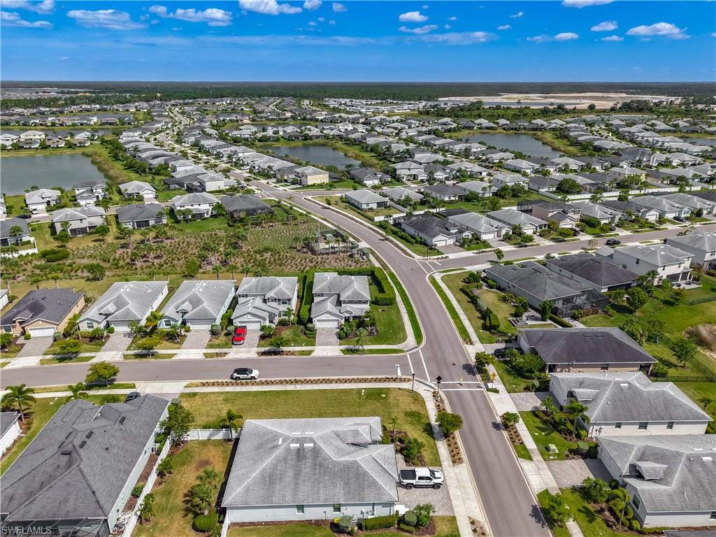 Aerial perspective of a developed residential community featuring diverse single-family homes with gray roofs