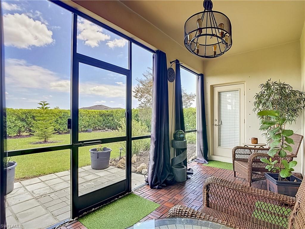 Screened patio featuring a Rustic chandelier and a Beautiful view of the Backyard.  The door at the end of the patio leads to the 2nd Half Bathroom