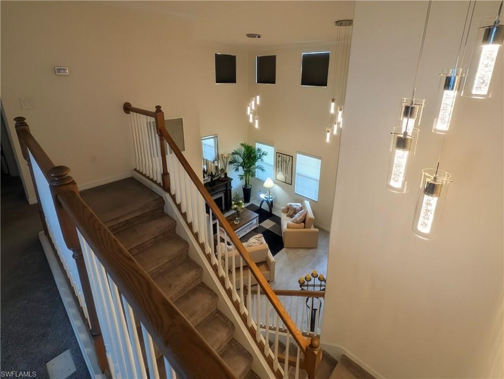 Two-story entryway with a grand staircase and modern pendant lighting fixtures
