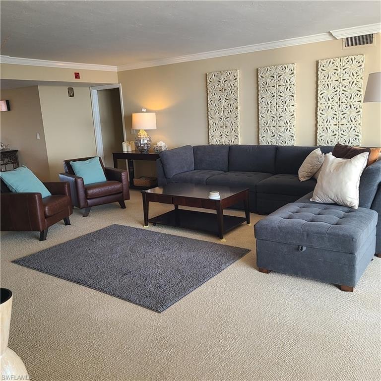 Living room with light colored carpet and crown molding