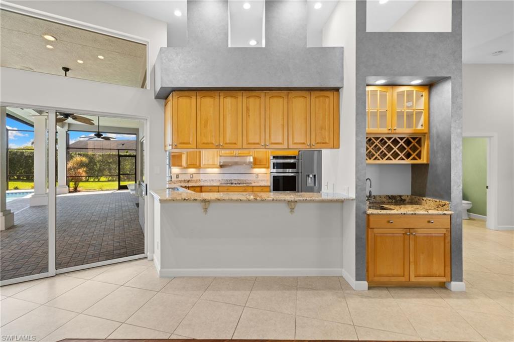 Kitchen with wood-finish cabinetry, granite countertops, and built-in appliances