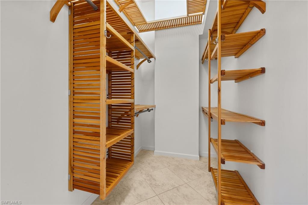 Primary bedroom #1 custom closet featuring natural wood-finish shelving and hanging rods