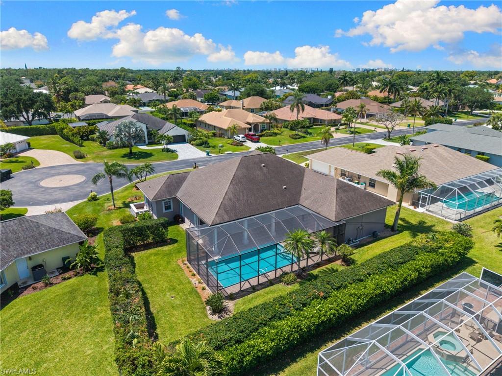 Spacious property featuring a screened-in swimming pool, mature landscaping, and a manicured lawn
