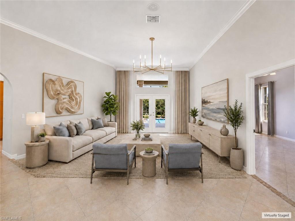Spacious living area featuring high ceilings, crown molding, and large format tile flooring