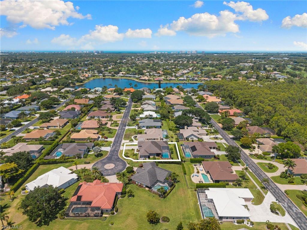 Aerial perspective showcasing the property's cul-de-sac location with a circular driveway and a private backyard pool