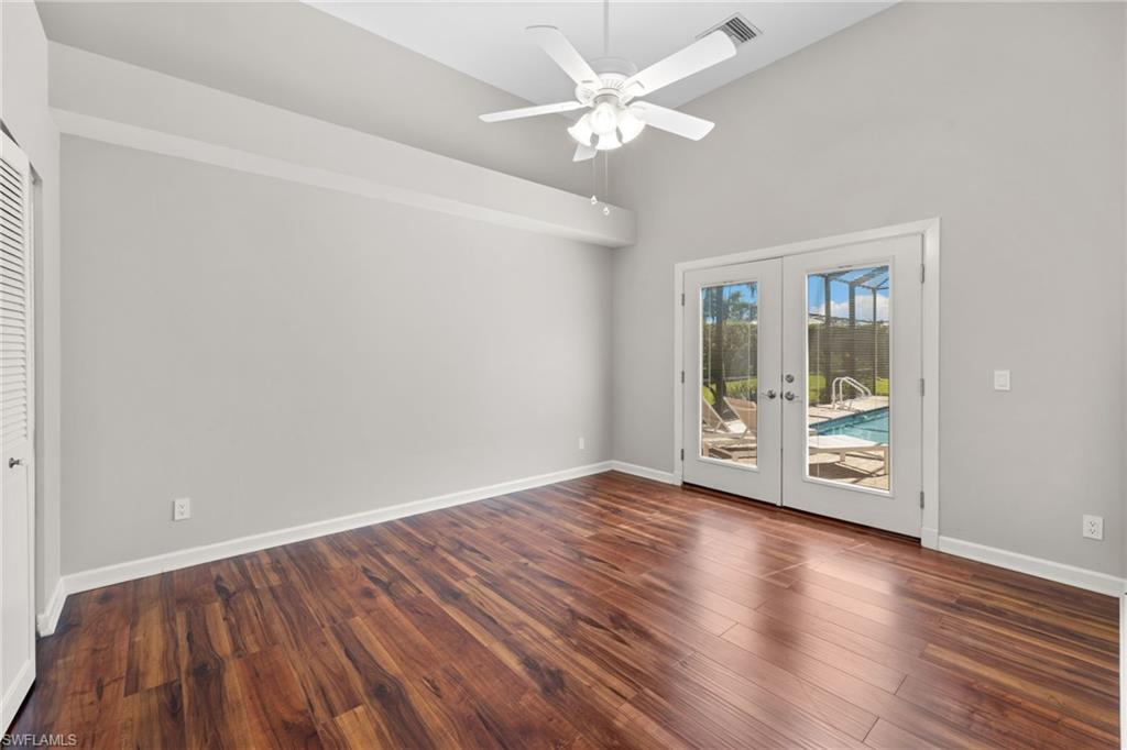 Bedroom #3, featuring bright interior, french doors to outdoor living space, spacious closet, wood-finish flooring, and a ceiling fan
