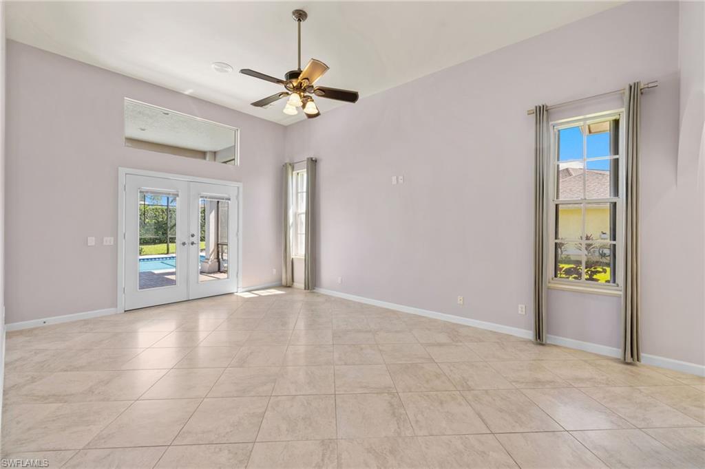 Primary bedroom #1, spacious interior featuring a light-toned tile floor, vaulted ceiling, and ceiling fan
