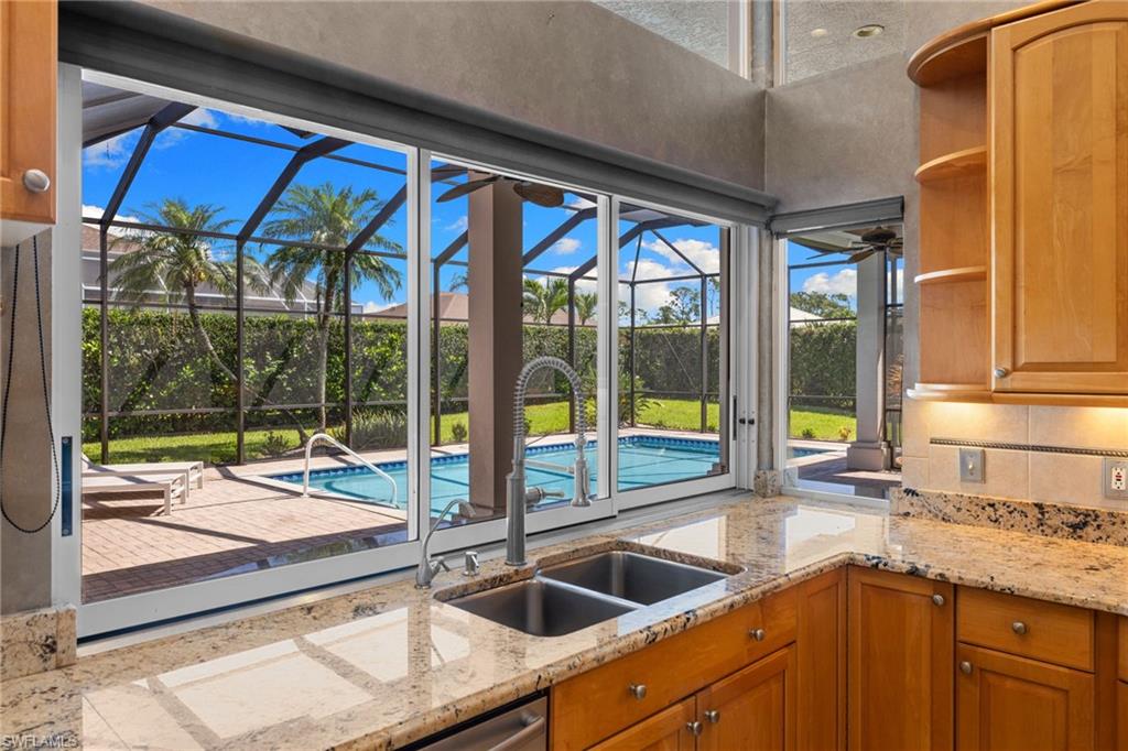 Kitchen featuring granite countertops, wood cabinetry, and a double basin sink