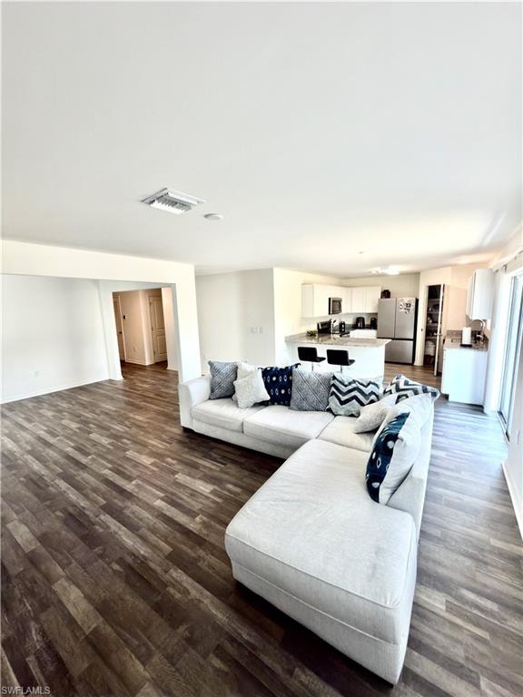 Expansive open-concept living space featuring wood-finish flooring, recessed lighting, and a neutral color palette