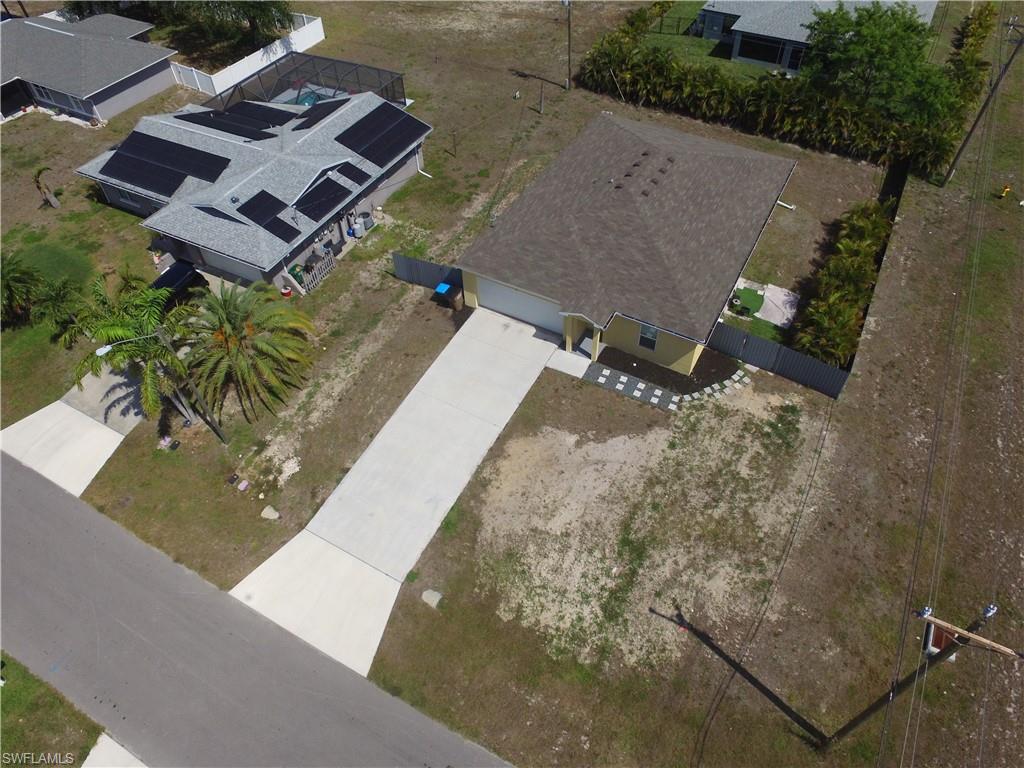 Single-story property with a light-colored exterior and a dark shingle roof